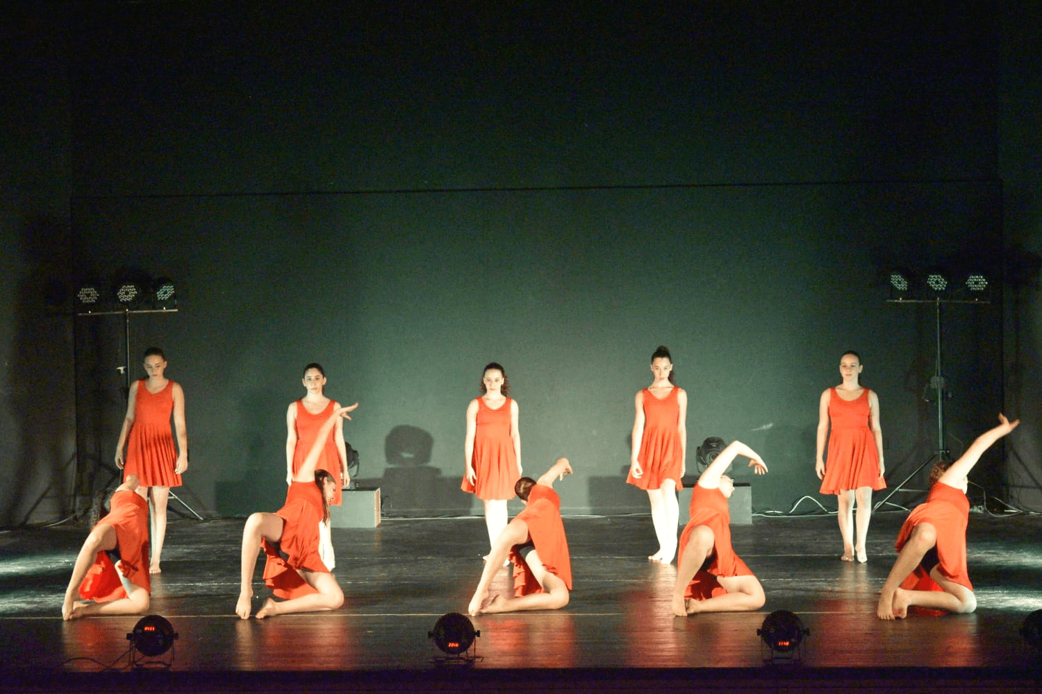 Group performance in red dresses with synchronized choreography