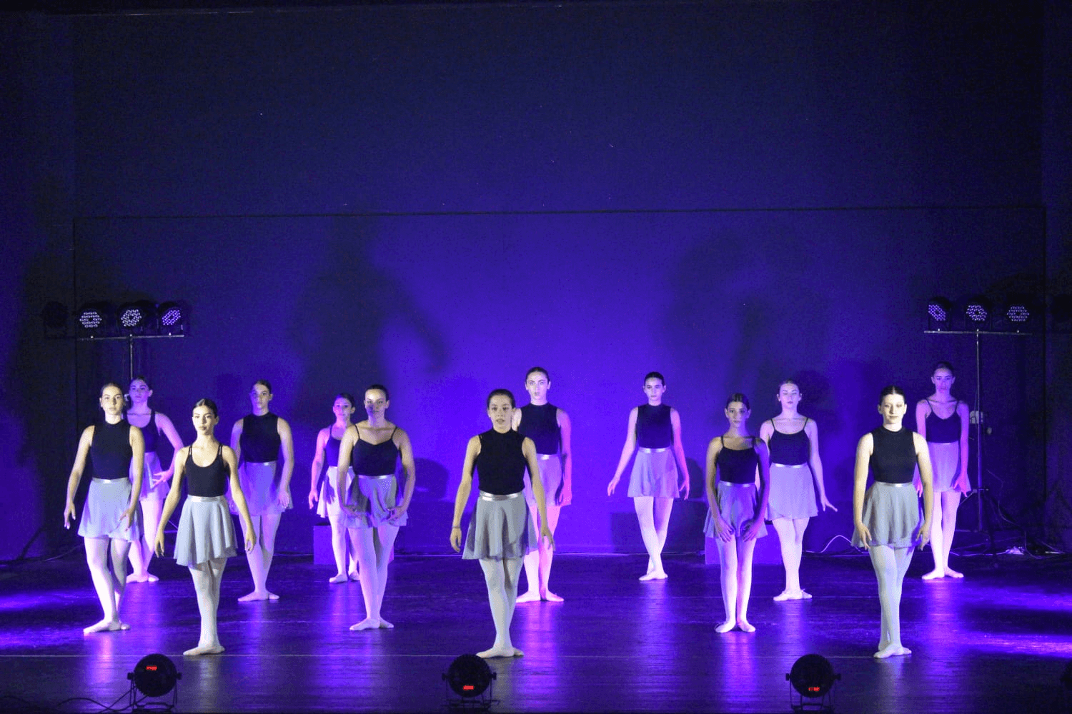 Group performance under purple lighting with contemporary choreography
